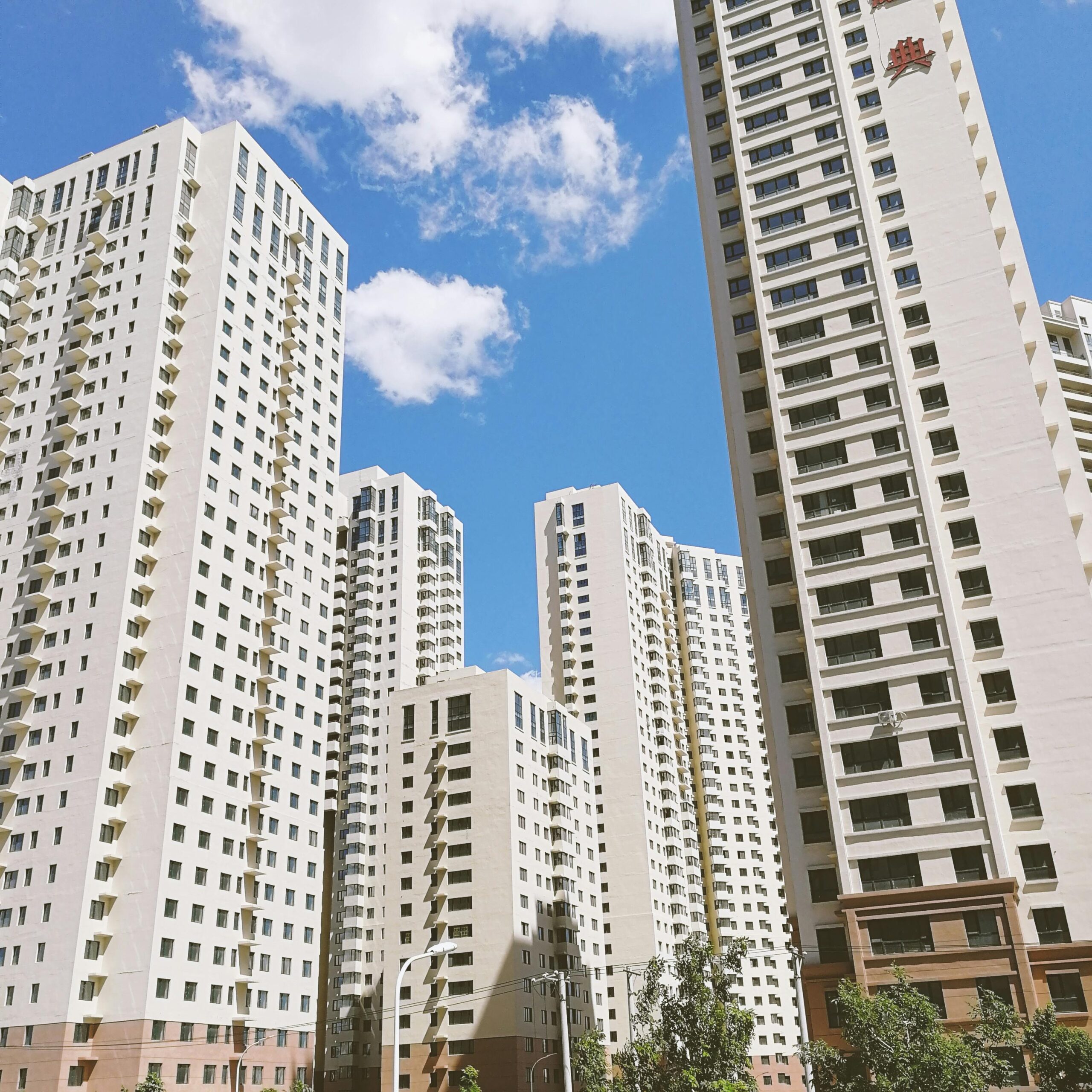 High-rise apartments in Harbin, China, under a clear blue sky. Modern urban architecture.